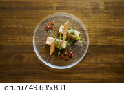 Top view of plate of foie micuit with crispy croutons and drops of marmalade on a wooden table in a fine dining restaurant.. Top view of plate of foie micuit with crispy croutons and drops of marmalade. Стоковое фото, агентство Ingram Publishing / Фотобанк Лори