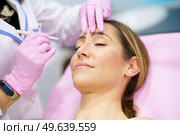 Aesthetic doctor painting on the face of his middle-aged patient the areas to be treated with botulinum toxin.. Aesthetic doctor painting on the face of his patient the areas to be treated with botulinum toxin. Стоковое фото, агентство Ingram Publishing / Фотобанк Лори