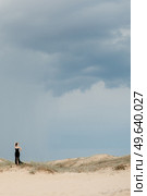 girl in a black long dress in a sandy desert under a blue sky. Стоковое фото, агентство Ingram Publishing / Фотобанк Лори