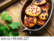 Cottage cheese pancakes or syrniki with summer berries. Curd pancakes with red and black currants on rural wooden table. Homemade syrniki with currants. Стоковое фото, агентство Ingram Publishing / Фотобанк Лори