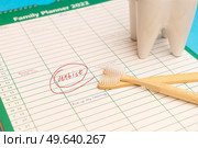 Oral care concept - tooth with toothbrushes over background with scheduled dentist visit. Oral care concept. Стоковое фото, агентство Ingram Publishing / Фотобанк Лори