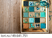 different azure beads and chrystals in box around old style wooden background. close up. Стоковое фото, агентство Ingram Publishing / Фотобанк Лори