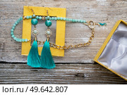 beautiful handmade  turquoise  jewelry with natural gems in yellow box around old style wooden background. close up. fashion concept. Стоковое фото, агентство Ingram Publishing / Фотобанк Лори