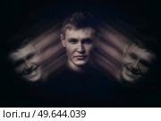 Bipolar young man with split personality and emotional disorder, hiding the real emotions, dissimulation concept. Inner emotional changes, mental health problem. Стоковое фото, агентство Ingram Publishing / Фотобанк Лори