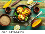 Vegan food, quinoa cutlet garnished with mango. Baked vegetarian burger. Vegetarian quinoa burgers. Стоковое фото, агентство Ingram Publishing / Фотобанк Лори
