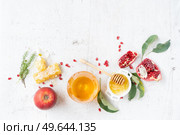rosh hashana holiday - honey with apple and pomergranate over white desk background. border with copy space. rosh hashana holiday. Стоковое фото, агентство Ingram Publishing / Фотобанк Лори