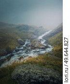 Mountain stream flowing fast across a rocky valley in Fagaras Mountains. River with high water debit during the rainy season. Стоковое фото, агентство Ingram Publishing / Фотобанк Лори
