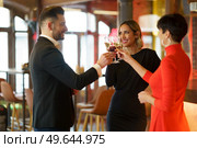 Group of happy elegant friends clinking glasses with champagne and celebrating reunion while gathering in luxury bar and looking at each other. Delighted friends clinking glasses in an elegant restaurant. Стоковое фото, агентство Ingram Publishing / Фотобанк Лори