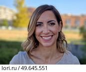 Portrait of a happy middle-aged woman in an urban park. Attractive female smiling to camera. Стоковое фото, агентство Ingram Publishing / Фотобанк Лори