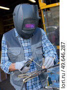 male in face mask welds with argon-arc welding. Стоковое фото, агентство Ingram Publishing / Фотобанк Лори