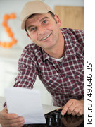 man holding instrucitons for installing a new hob. Стоковое фото, агентство Ingram Publishing / Фотобанк Лори