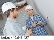 foreman showing dismantled socket to eapprentice electrician. Стоковое фото, агентство Ingram Publishing / Фотобанк Лори