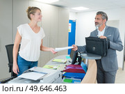 female employee show pack of documents to busy businesman. Стоковое фото, агентство Ingram Publishing / Фотобанк Лори