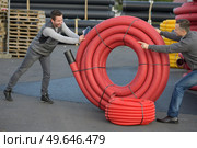 happy workers moving heavy pipes outdoors. Стоковое фото, агентство Ingram Publishing / Фотобанк Лори