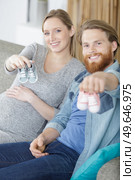 crop couple with tiny footwear on hands. Стоковое фото, агентство Ingram Publishing / Фотобанк Лори