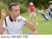 concentrated golfer taking a shot at golf course. Стоковое фото, агентство Ingram Publishing / Фотобанк Лори