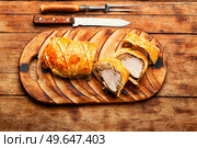 Meat dish is wellington meat, meat baked in dough. Meat loafs on old wooden table. Appetizing Wellington meat. Стоковое фото, агентство Ingram Publishing / Фотобанк Лори
