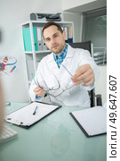 doctor giving eyeglasses to patient. Стоковое фото, агентство Ingram Publishing / Фотобанк Лори