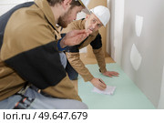 tiler and co-worker at indoor floor tiling renovation. Стоковое фото, агентство Ingram Publishing / Фотобанк Лори