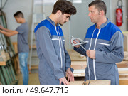 industrial workers using a protractor at factory workshop. Стоковое фото, агентство Ingram Publishing / Фотобанк Лори