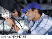 engineer working with cables in the roof. Стоковое фото, агентство Ingram Publishing / Фотобанк Лори