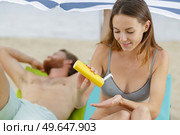 woman applying suncream on the beach. Стоковое фото, агентство Ingram Publishing / Фотобанк Лори