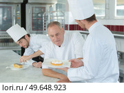 chef assessping pudding made by trainee chef. Стоковое фото, агентство Ingram Publishing / Фотобанк Лори