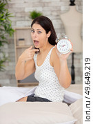 shocked young woman waking up with alarm. Стоковое фото, агентство Ingram Publishing / Фотобанк Лори