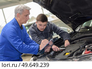 mechanic checked in the engine compartment of a car. Стоковое фото, агентство Ingram Publishing / Фотобанк Лори