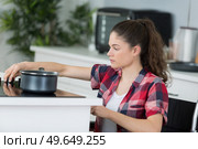 disabled young woman in wheelchair cooking dinner. Стоковое фото, агентство Ingram Publishing / Фотобанк Лори
