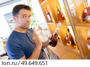 a man in an expensive liquor shop. Стоковое фото, агентство Ingram Publishing / Фотобанк Лори