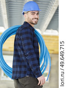 happy male builder holding pipes. Стоковое фото, агентство Ingram Publishing / Фотобанк Лори