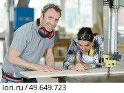 female apprentice learning to saw. Стоковое фото, агентство Ingram Publishing / Фотобанк Лори