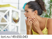 young woman checking her skin. Стоковое фото, агентство Ingram Publishing / Фотобанк Лори