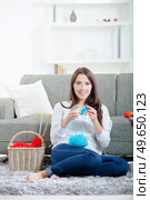 Woman sat on floor knitting. Стоковое фото, агентство Ingram Publishing / Фотобанк Лори