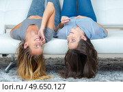 girls laughing watching something in their smart phones. Стоковое фото, агентство Ingram Publishing / Фотобанк Лори