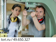 man working with female apprentice in factory. Стоковое фото, агентство Ingram Publishing / Фотобанк Лори