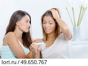 young woman holding a pregnancy test. Стоковое фото, агентство Ingram Publishing / Фотобанк Лори