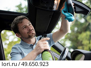 man is cleaning his car inside. Стоковое фото, агентство Ingram Publishing / Фотобанк Лори