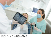 dentist with teeth x-ray on tablet and patient. Стоковое фото, агентство Ingram Publishing / Фотобанк Лори