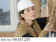 female worker placing styrofoam sheet insulation to wall. Стоковое фото, агентство Ingram Publishing / Фотобанк Лори