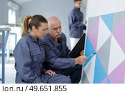 supervisor assessing trainee decorators work. Стоковое фото, агентство Ingram Publishing / Фотобанк Лори