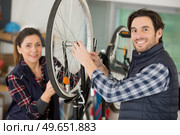 competent bicycle mechanic in a workshop repairs a bike. Стоковое фото, агентство Ingram Publishing / Фотобанк Лори