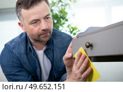 man using sandpaper on a painted cupboard. Стоковое фото, агентство Ingram Publishing / Фотобанк Лори