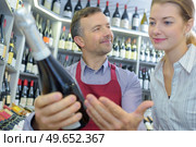 young woman deciding what wine to buy in supermarket. Стоковое фото, агентство Ingram Publishing / Фотобанк Лори