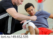 sports coach bandaging knee injury. Стоковое фото, агентство Ingram Publishing / Фотобанк Лори