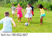 Happy preteen girls and boys playing football on green lawn. Стоковое фото, фотограф Яков Филимонов / Фотобанк Лори