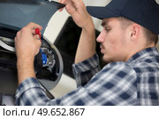 man repairing photocopier using screwdriver. Стоковое фото, агентство Ingram Publishing / Фотобанк Лори
