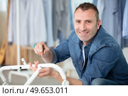 happy man assembling a metal chair with allen-key. Стоковое фото, агентство Ingram Publishing / Фотобанк Лори