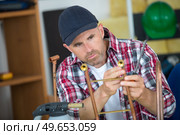a plumber inspecting copper rod. Стоковое фото, агентство Ingram Publishing / Фотобанк Лори